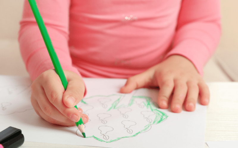 meisje kleurt een tekening met groen potlood