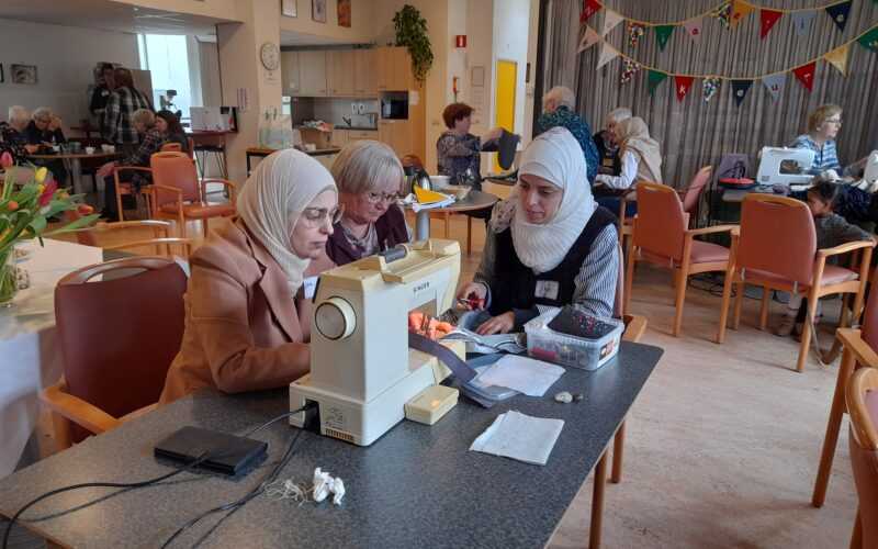 vrouwen samen achter een naaimachine aan het werk